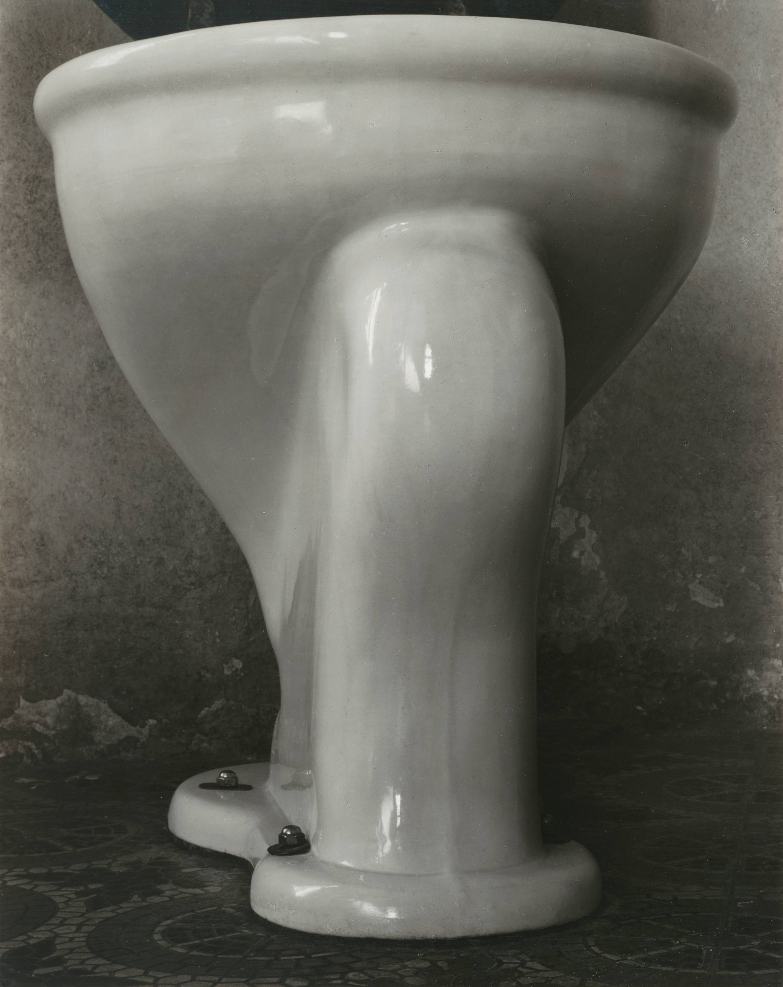 “Form follows function.” Who said this I don’t know, but the writer spoke well! I have been photographing our toilet, that glossy enameled receptacle of extraordinary beauty. It might be suspicioned that I am in a cynical mood to approach such subject matter when I might be doing beautiful women or “God’s out-of-doors” — or even considered that my mind holds lecherous images arising from restraint of appetite. But no! My excitement was absolute aesthetic response to form. For long I have considered photographing this useful and elegant accessory to modern hygenic life, but not until I actually contemplated its image on my ground-glass did I realize the possibilities before me. I was thrilled! Here was every sensuous curve of the “human form divine” but minus imperfections.
Never did the Greeks reach a more significant consummation to their culture, and it somehow reminded me, in the glory of its chaste convolutions and in its swelling, sweeping, forward movement of finely progressing contours, of the Victory of Samothrace. Yet the blind will turn longingly back to “classic days” for art! Now I eagerly await the development of my exposed film.
— Edward Weston Medieval garderobe